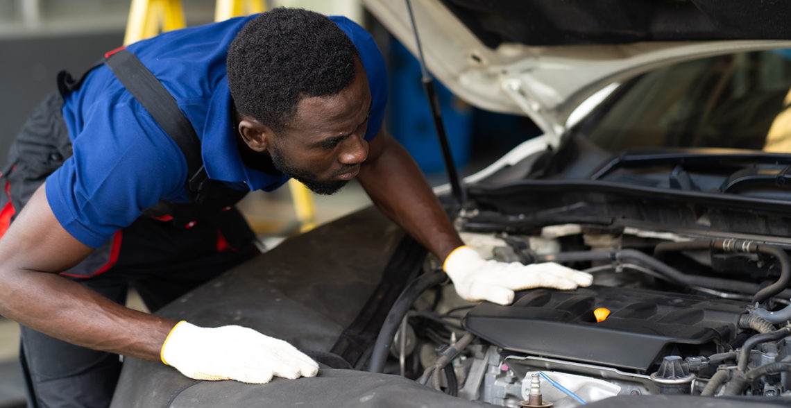 Technician working on car engine